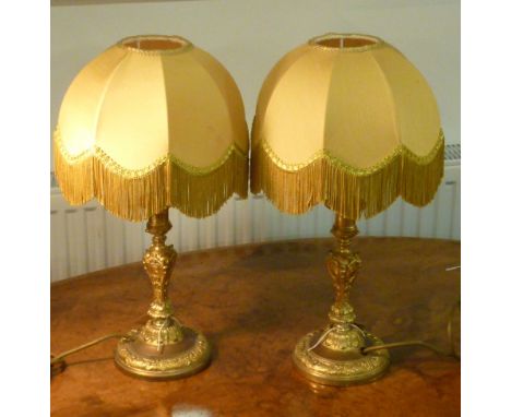 A pair of 19th century gilt metal Candlesticks as lamps with Shades, the Lamps cast with foliate ornament, shells and 'C' scr