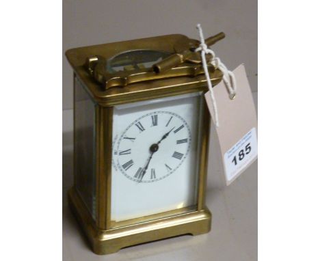 A late 19th/early 20th century brass and glass-sided Carriage Clock, gilded movement and white enamel dial with Roman numeral