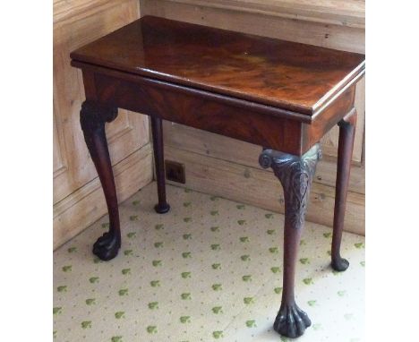 A mid 18th century foldover top figured mahogany Tea Table in the Irish style, the front legs carved at the knees with foliat