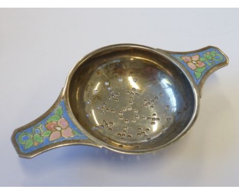 An Arts and Crafts style silver and enamel Strainer by Bernard Instone, the handles decorated with Celtic style enamel flower