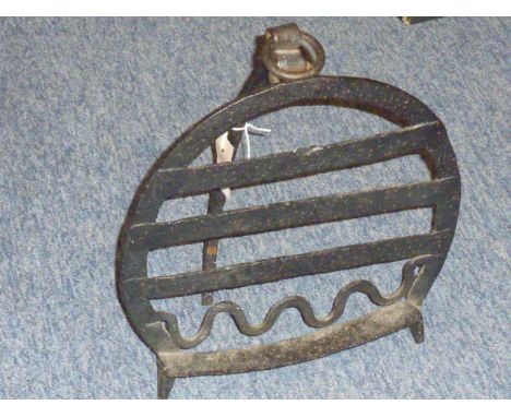 A large early 19th century wrought iron Fire Trivet of horseshoe design, with suspension loop and hinged arched back rest and
