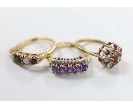 Three 9ct gold dress rings: white opal and ruby, size L, diamond and amethyst, size L and ruby and diamond, size M