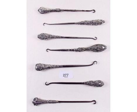 Seven silver handled button hooks 