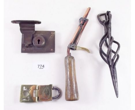 An old brass tamper proof London Electricity padlock, another padlock,  a copper flint lighter and two blacksmiths items 