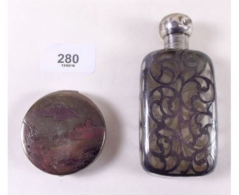 A silver compact decorated Japanese landscape and a silver clad toiletry bottle