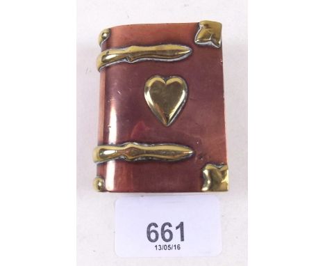 An old brass and copper book form cigarette lighter 