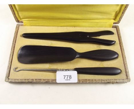 An ebony shoe horn, glove stretchers and button hook, cased