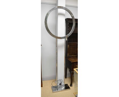 A contemporary chrome floorstanding lamp, with central light ring raised on two squared pillar supports, over rectangular blo
