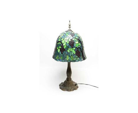 A 20th Century table lamp, the stained and leaded glass style shade decorated with red fruiting vines and leaves in shades of