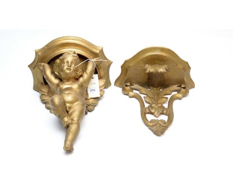 An Italian gilt gesso wall bracket, the bowfront shelf with putti support, 35cms high; together with another. (2)
