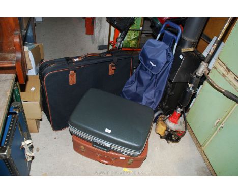 Three suitcases and a hopper shopping trolley.