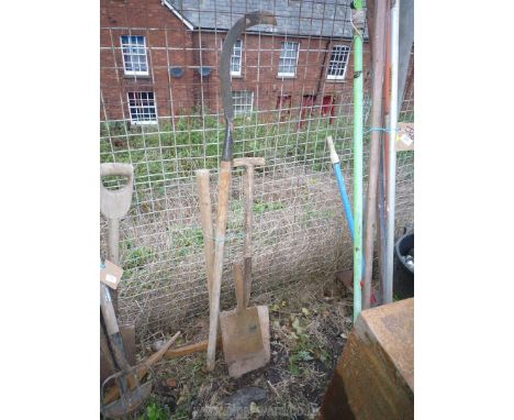 Two spades (one without handle), a hedge hook and a pick-axe.