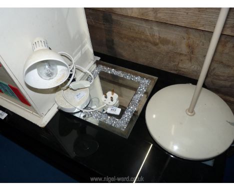 A mirror. small angle poise lamp and standing spot light.