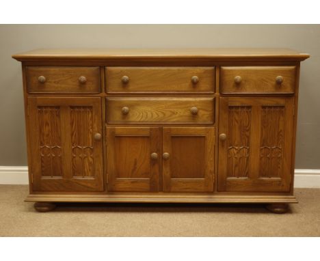 Ercol golden dawn finish sideboard with four drawers and four cupboards, W155cm, H89cm, D52cm   Condition Report   Click here