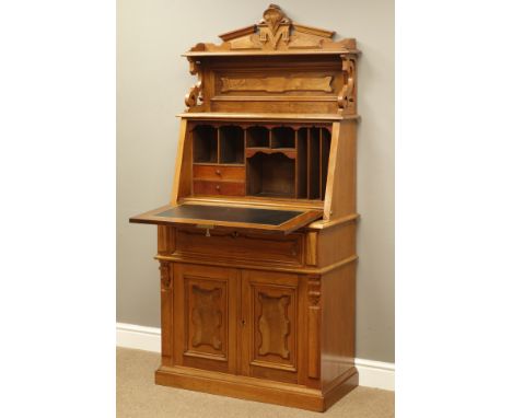 Late 19th century walnut writing desk, carved broken arched top above shelf, s-scrolled supports, sloped hinged fall front wi