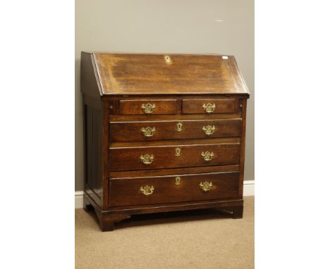 George III oak bureau, sloped hinged front, stepped interior with pull out correspondence trays, two short and three long gra