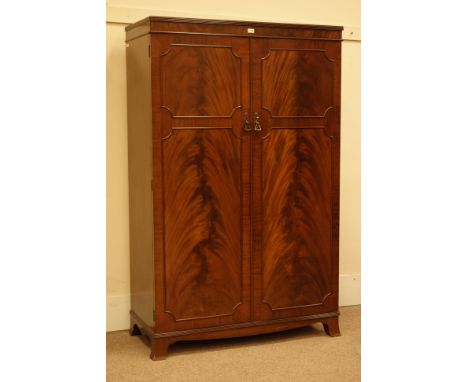 Early 20th century figured mahogany double wardrobe, interior fitted with shelving, drawers and hanging space, splayed bracke