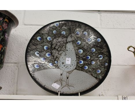 A good large Poole pottery charger painted with a peacock.