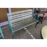 A garden bench with green painted cast metal ends.