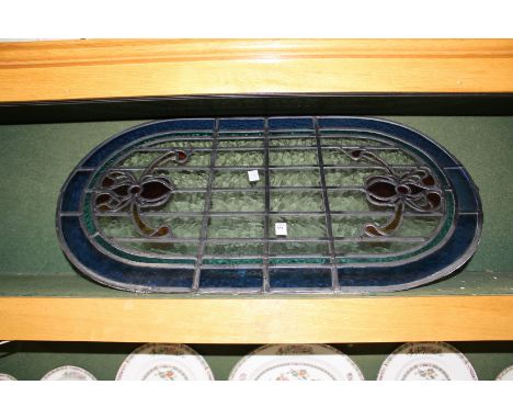 An oval leaded light stained glass window panel.