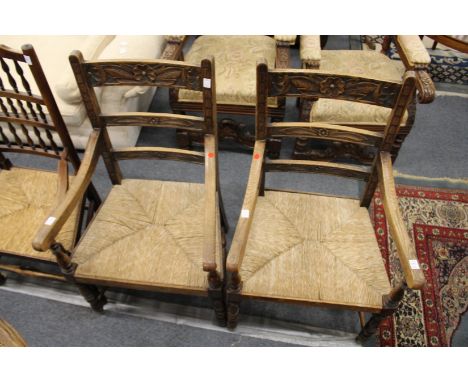 A pair of rush seated oak ladder back armchairs.