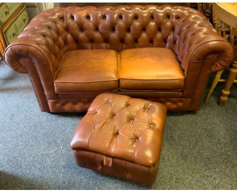 A leather Chesterfield two seat sofa;  foot stool ensuite 