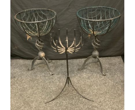 A pair of circular wirework basket planters, spiral vortex column, tripod feet, 64.5cm high, 43cm diameter;  another smaller 