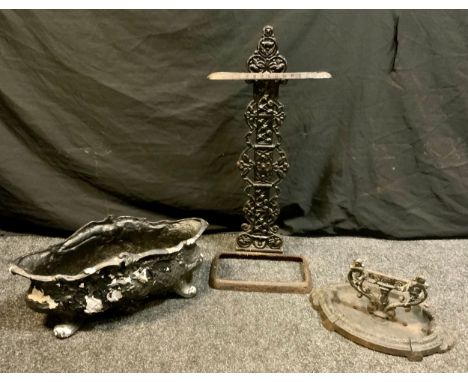A cast iron shaped oval planter, cast floral lattice body, 21cm high, 49cm long, 22cm wide;  a boot scraper;  stick stand 