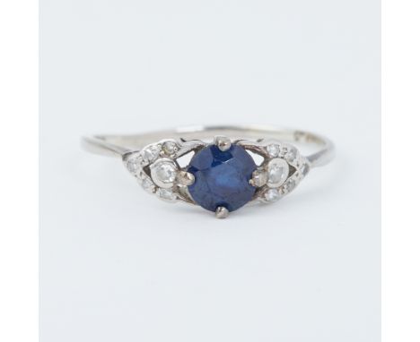 An 18ct white gold &amp; platinum Art Deco ring set with a central round cut sapphire, approx. 0.76 carats, with small round 