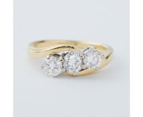 An 18ct yellow &amp; white gold three stone twist ring set with three round brilliant cut diamonds, total diamond weight appr