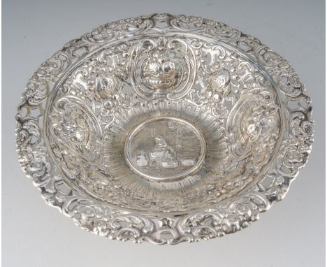An early 20th Century Hanau 800 standard silver raised bowl., the centre chased with a Lady sorting fruit by four baskets., t