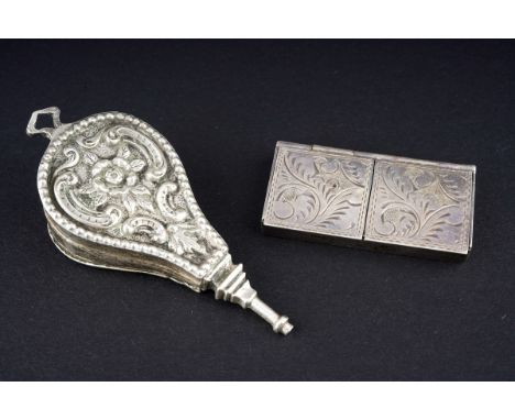 An early 20th Century novelty silver bellow shaped pill box and cover, embossed with a seated figure to front, flowers to rev