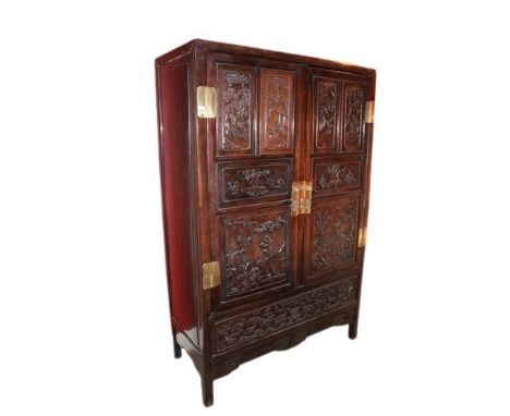 A carved hardwood Cabinet (GUI) Qing Dynasty, of rectangular outline with a pair of hinged doors separated by a central tile,