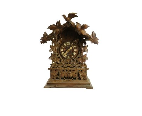 An early 20th Century oak and walnut Austrian&nbsp;'Cuckoo' Clock,&nbsp;the arched cornice with leaf decoration and bird, ove