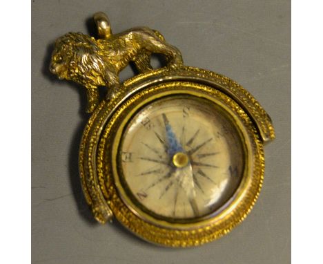 A gilt swivel fob inset with a compass, surmounted by a Lion