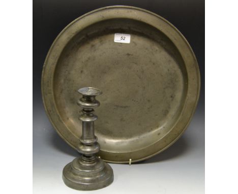 An 18th Century pewter candlestick; an early 19th Century pewter charger (2)