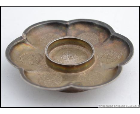 A Chinese silver tea light stand with decorative circular cartouche panel work, the body in the form of a lotus flower bearin
