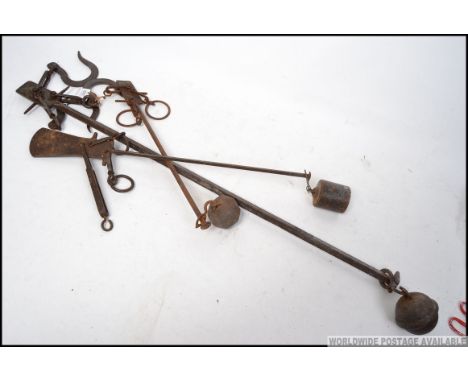 A pair of 19th century fireside potjacks / game scales made of cast iron complete with the ball weights and the hooks