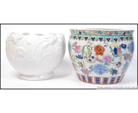 A large Chinese ceramic planter highly decorated with colourful panels along with a similar sized planter. H28cm 