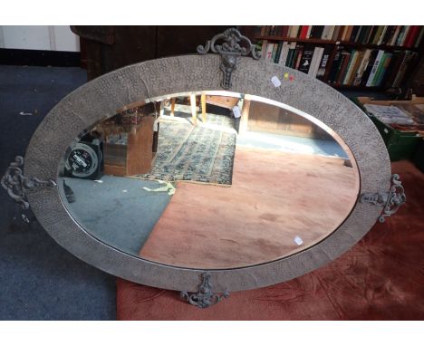 ARTS AND CRAFTS OVAL MIRROR in a hammered pewter frame