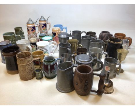 A large quantity of tankards including pewter, wood, ceramic, glass and a pair of musical steins 