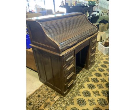 An early 20th century roll top desk. W:122cm x D:65cm x H:113cm