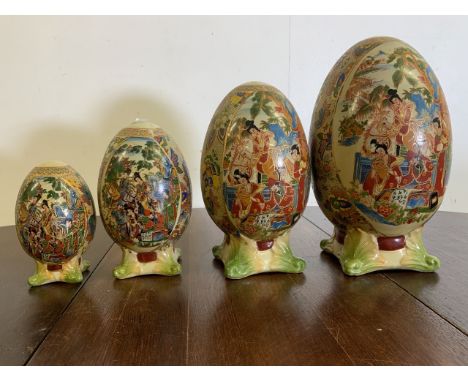 Four graduated ceramic oriental transfer and overpainted eggs on stand. Largest H:30cm