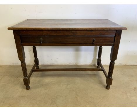 An oak desk table with large central drawer with brass handles. W:96cm x D:50cm x H:67cm