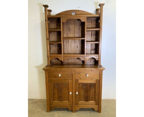 A two piece country pine kitchen dresser. Decorative top with pigeon hole shelves, base with two drawers above cupboard ceram