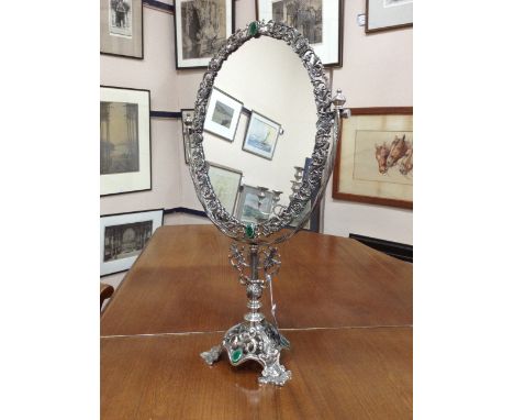 ATTRACTIVE SILVER PLATED DRESSING GLASS in the Art Nouveau fashion, the oval dressing glass with pierced scroll and floral bo