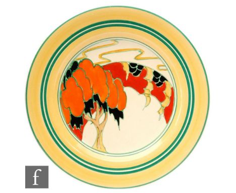 Clarice Cliff - Solitude - A circular plate circa 1933, hand painted with a stylised tree before a bridge with orange and yel