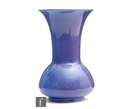 Ruskin Pottery - A large souffle glazed vase of globe and flared shaft form decorated in an all over purple blue glaze, impre