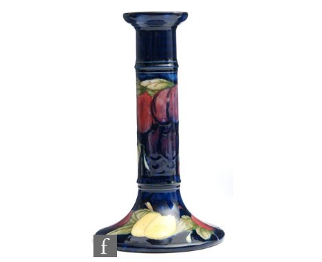 William Moorcroft - A candlestick of typical form decorated in the Wisteria pattern, impressed mark alongside blue initials, 