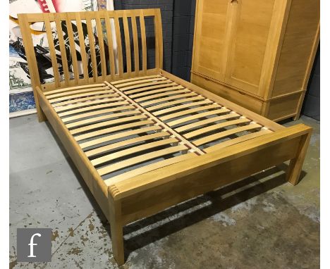 Ercol Furniture - A light oak Bosco range double bed frame, with curved finger joint detailing, height of headboard 108cm and